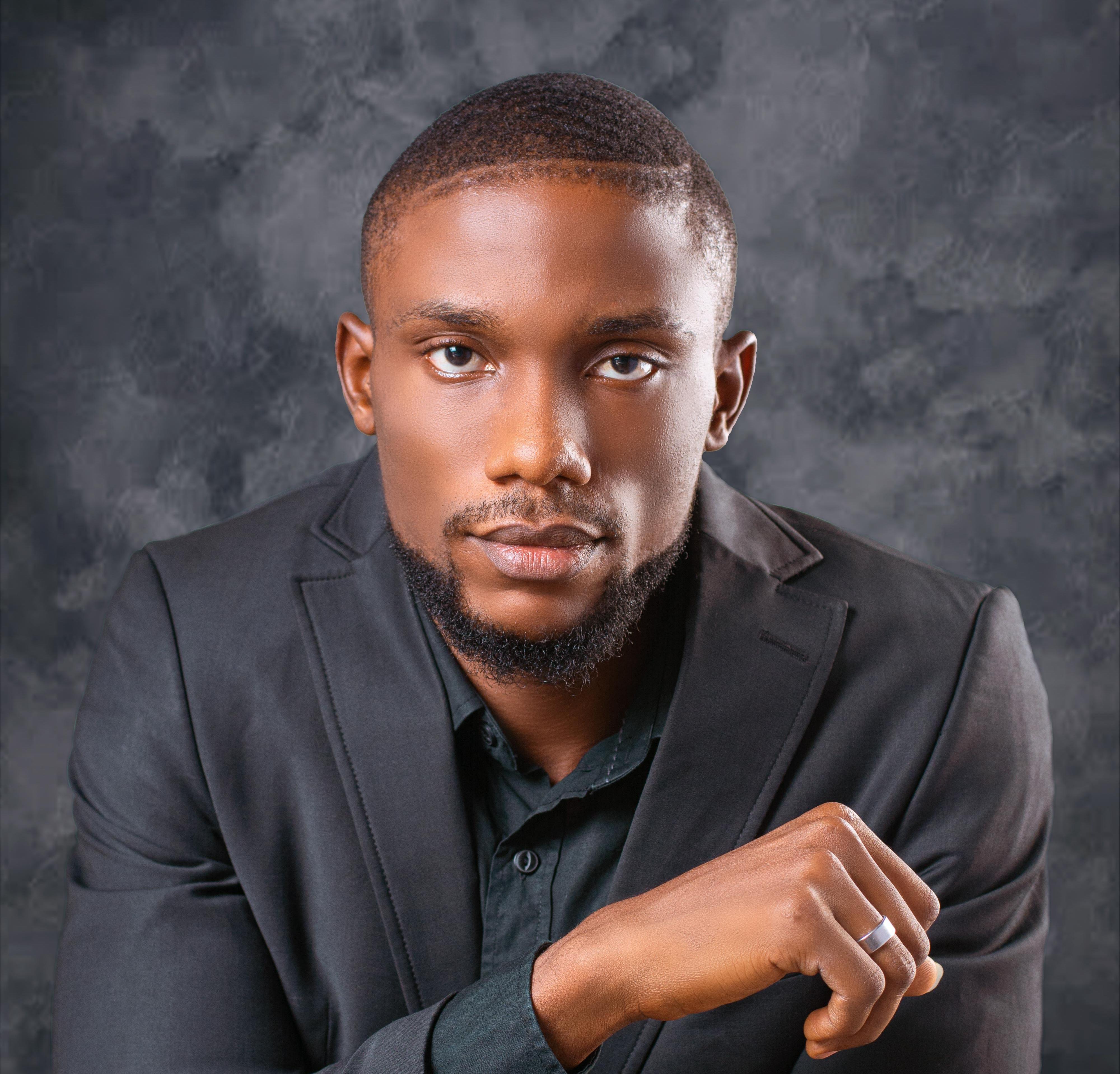 A professional portrait of a charismatic Black male executive in a sharp tailored navy suit, confident expression, minimalist dark studio background, high-end editorial style